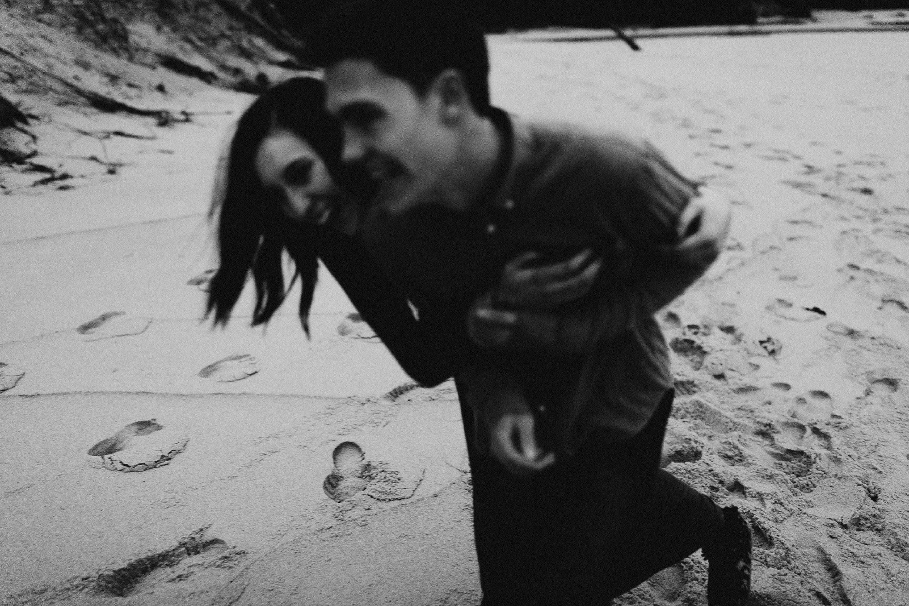 Laughing and goofing off on the shoreline of Lake Superior Playful Lake Superior Destination Engagement Session