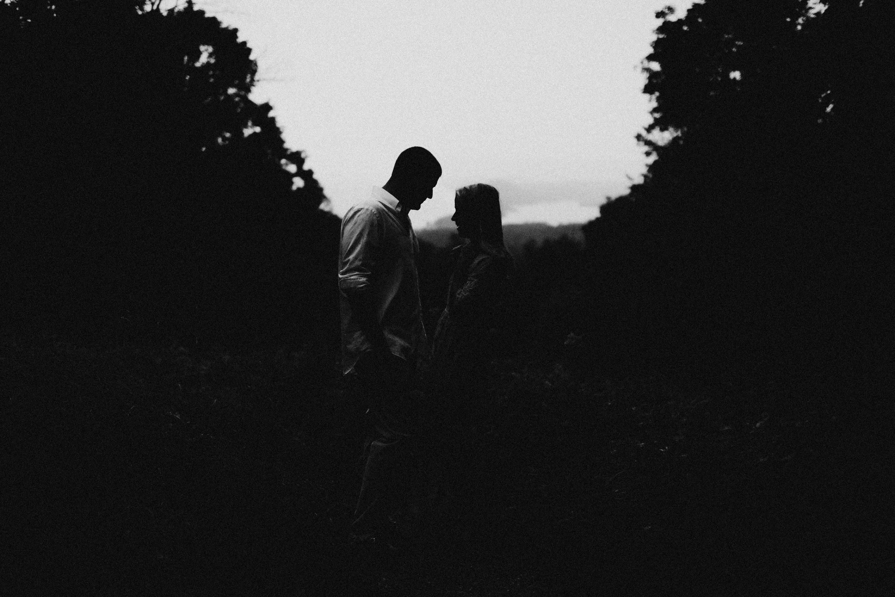 Couple holding each other close in a storm Windy, Empire Bluffs, Engagement Session, Josh Rexford